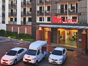 two cars and a truck parked in front of a building at Ibis Phuket Kata in Kata Beach