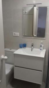 een badkamer met een wastafel, een spiegel en een toilet bij Los Lances Pastor in Tarifa