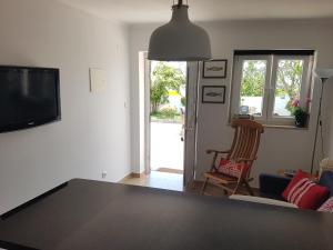 uma sala de estar com uma mesa preta e uma televisão em The Sun House em Santa Iria da Azóia