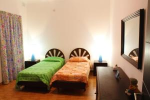 a bedroom with two beds and a mirror at Maltarentapartments in Marsaskala
