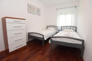 two twin beds in a bedroom with a dresser at Sun and sea apartment in Zadar