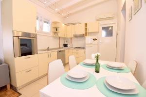 a kitchen and dining room with a table and chairs at Sun and sea apartment in Zadar