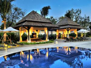 a pool at a resort with umbrellas and chairs at Ibis Phuket Kata in Kata Beach