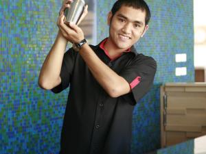 a man holding up a cell phone in a bathroom at Ibis Phuket Kata in Kata Beach