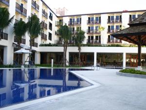 a hotel with a swimming pool in front of a building at Ibis Phuket Kata in Kata Beach