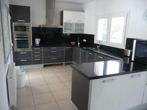 eine Küche mit schwarzen und weißen Arbeitsflächen und Geräten in der Unterkunft Casa del Erizo in Moraira