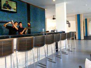two people standing at a bar in a restaurant at Ibis Phuket Kata in Kata Beach