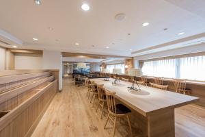 a large room with a row of tables and chairs at HOTEL MYSTAYS PREMIER Sapporo Park in Sapporo