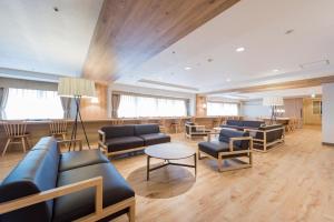 una sala de espera con sofás, sillas y una mesa en HOTEL MYSTAYS PREMIER Sapporo Park, en Sapporo