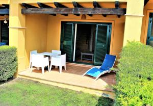 une terrasse avec une table et des chaises dans une maison dans l'établissement Sierra Cortina jardín, sol y playa, à Finestrat