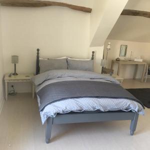a bedroom with a bed with a blue bedspread at Riverside Barn in La Trimouille