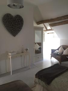 a bedroom with a heart hanging on the wall at Riverside Barn in La Trimouille