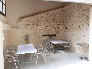 2 mesas y sillas en una habitación con pared en Gite de la fontaine Marsi, en Saint-Mars-la-Réorthe