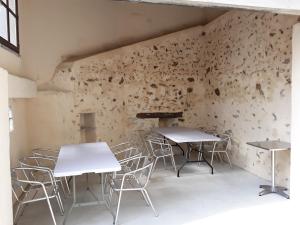 - deux tables et des chaises dans une pièce avec un mur dans l'établissement Gite de la fontaine Marsi, à Saint-Mars-la-Réorthe
