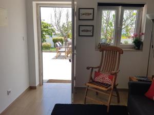 sala de estar con mecedora y puerta abierta en The Sun House en Santa Iria da Azóia