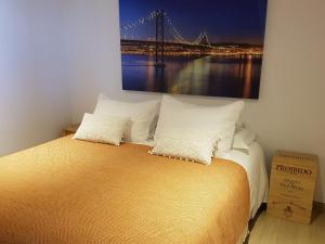 a bedroom with a bed with a painting on the wall at The Sun House in Santa Iria da Azóia