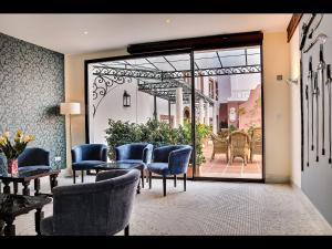 Habitación con sillas, mesa y puerta de cristal en Apartamentos Murillo, en Sevilla