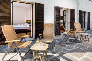 a group of chairs sitting on a patio with a piano at Hotel Bellinzona Sud Swiss Quality in Monte Carasso