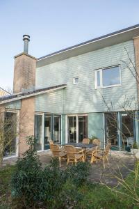 ein Haus mit Stühlen und einem Tisch davor in der Unterkunft Haags Duinhuis - familyfriendly holidayhome in Den Haag