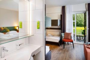 a hotel room with a bathroom and a bedroom at Hotel Bellinzona Sud Swiss Quality in Monte Carasso