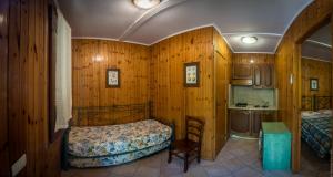 una camera da letto con pareti in legno, un letto e un lavandino di Camping Nube D'Argento a Sorrento