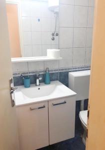 a bathroom with a sink and a toilet and a mirror at Adria Apartment in Hvar
