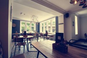 a dining room with tables and chairs and windows at The Hurt Arms in Whatstandwell