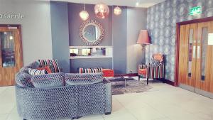 a living room with chairs and a table and a mirror at Smiths At Gretna Green Hotel in Gretna Green