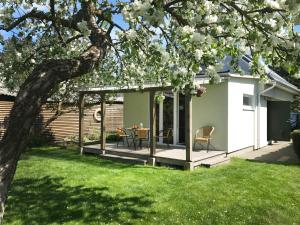 a garden room with a table and chairs on a deck at Namelis Palangoje in Palanga