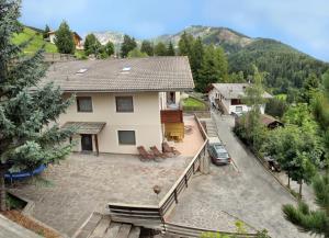 Elle offre une vue aérienne sur une maison dotée d'une terrasse. dans l'établissement Apartment Kristyn, à Ortisei