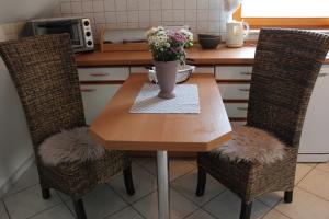 a kitchen table with a vase of flowers on it at Ferienwohnung Stadtidyll in Michelstadt +6 photos
