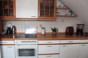 a kitchen with white cabinets and a stove top oven at Ferienwohnung Stadtidyll in Michelstadt