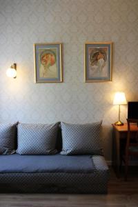 une chambre avec un canapé et deux photos sur le mur dans l'établissement Pensjonat Irena, à Sopot