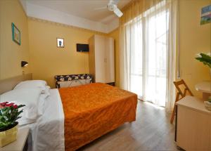 リミニにあるHotel Festivalのベッドと大きな窓が備わるホテルルームです。