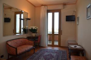 a living room with a chair and a mirror at Parc Hotel Casa Mia in Lazise