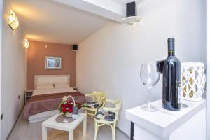 a room with a bed and a table with a wine bottle at Klaris Guest house in Budva