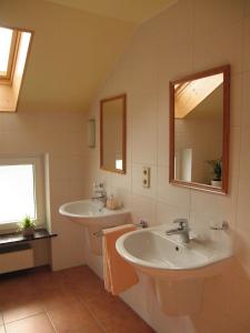La salle de bains est pourvue de 2 lavabos et de 2 miroirs. dans l'établissement Ferienwohnung Hubner, à Bernlohe