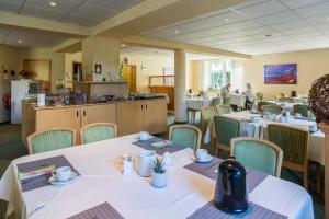 a restaurant with tables and chairs with people in the background at Pension Maiglöckchen in Ostseebad Karlshagen