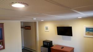 a room with a flat screen tv on a wall at Atlantic Motel in Point Pleasant Beach