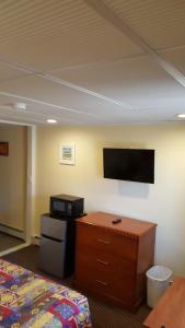a hotel room with a desk and a tv on the wall at Atlantic Motel in Point Pleasant Beach