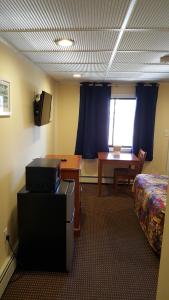 a room with a bed and a desk and a table at Atlantic Motel in Point Pleasant Beach