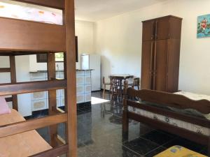 a room with two bunk beds and a kitchen at Kitnets Park Verde in Peruíbe