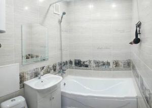 a bathroom with a tub and a toilet and a sink at Апартаменты на Луначарского in Tyumen