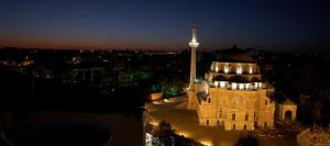 a building with a tall tower with a lit up mosque at Martinenz Hotel Old City in Istanbul