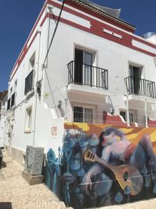 ラゴスにあるCloud 9 Hostelのギターを弾く男の壁画のある建物
