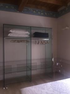 a glass cabinet in a room with a bed at Palazzo Carasi Apartments in Cremona