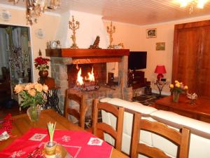 a living room with a fireplace and a dining room table with a table at Chambres d'hôtes Al Camp d'Espalougues in Ur