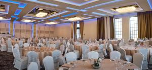 a ballroom with tables and white chairs in a room at ibis Styles Arad in Arad +41 photos