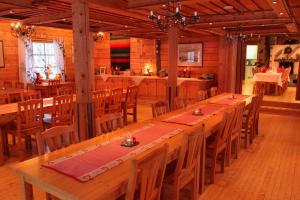 a large dining room with a long table and chairs at Isokenkäisten Klubi - Wilderness Lodge in Kiviperä
