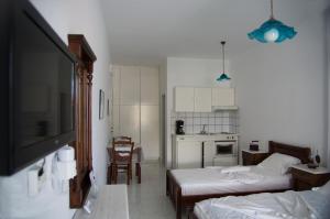 a small room with two beds and a kitchen at Erato Apartments in Batsi